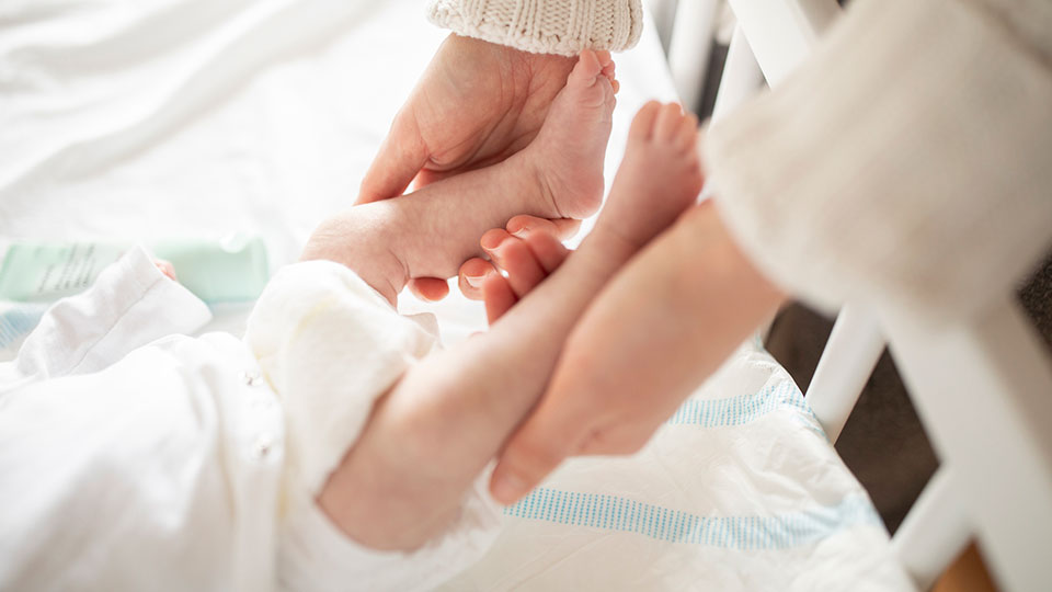 Mom holding newborn baby's feet