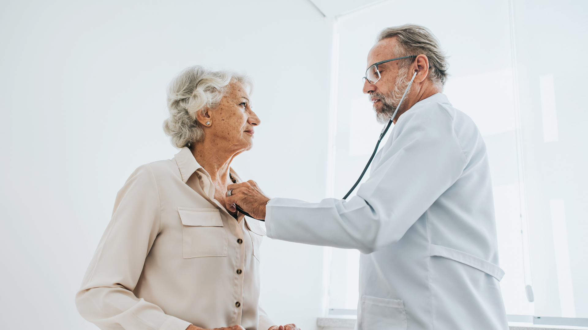 Doctor listening to senior woman patient heartbeat