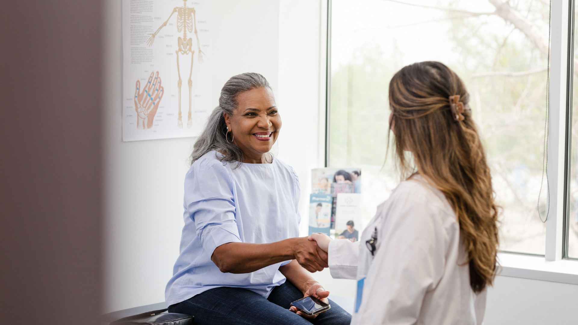 Smiling Patient Shaking Hands with Doctor in Clinic