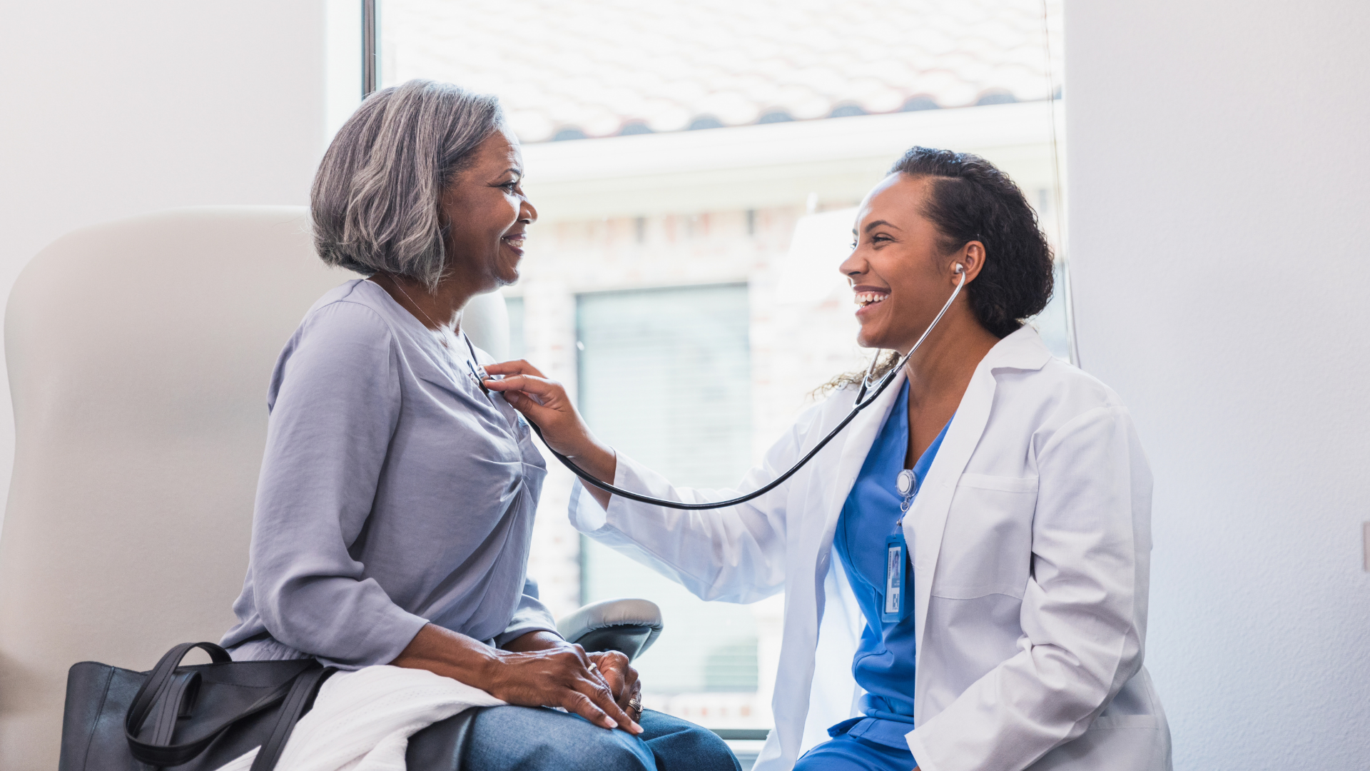 Cheerful doctor listens to patient's heartbeat