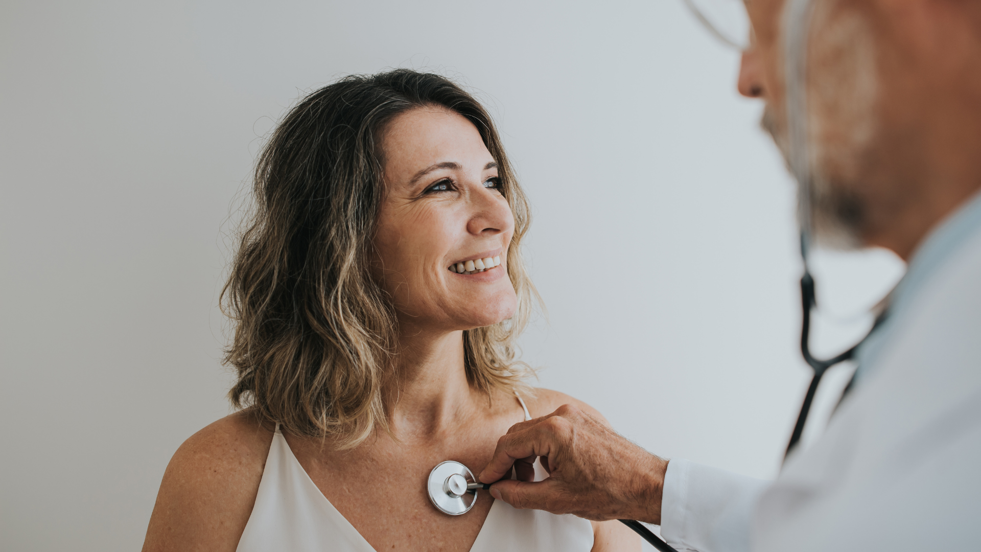 Doctor listening to patient's heart with stethoscope