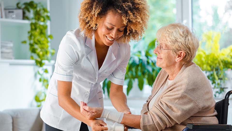 Nurse treating wound of older woman