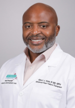 Albert Hicks posing and smiling in a white coat