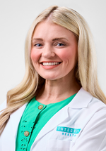 Anna Hooks smiling and posing in a white coat