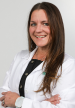 Deanna Carey smiling and posing in a white coat