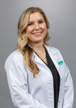 Jordan Harris smiling and posing in a white coat