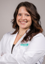 Kendall Creed smiling and posing in a white coat