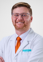 Matthew Frantz posing and smiling in a white coat