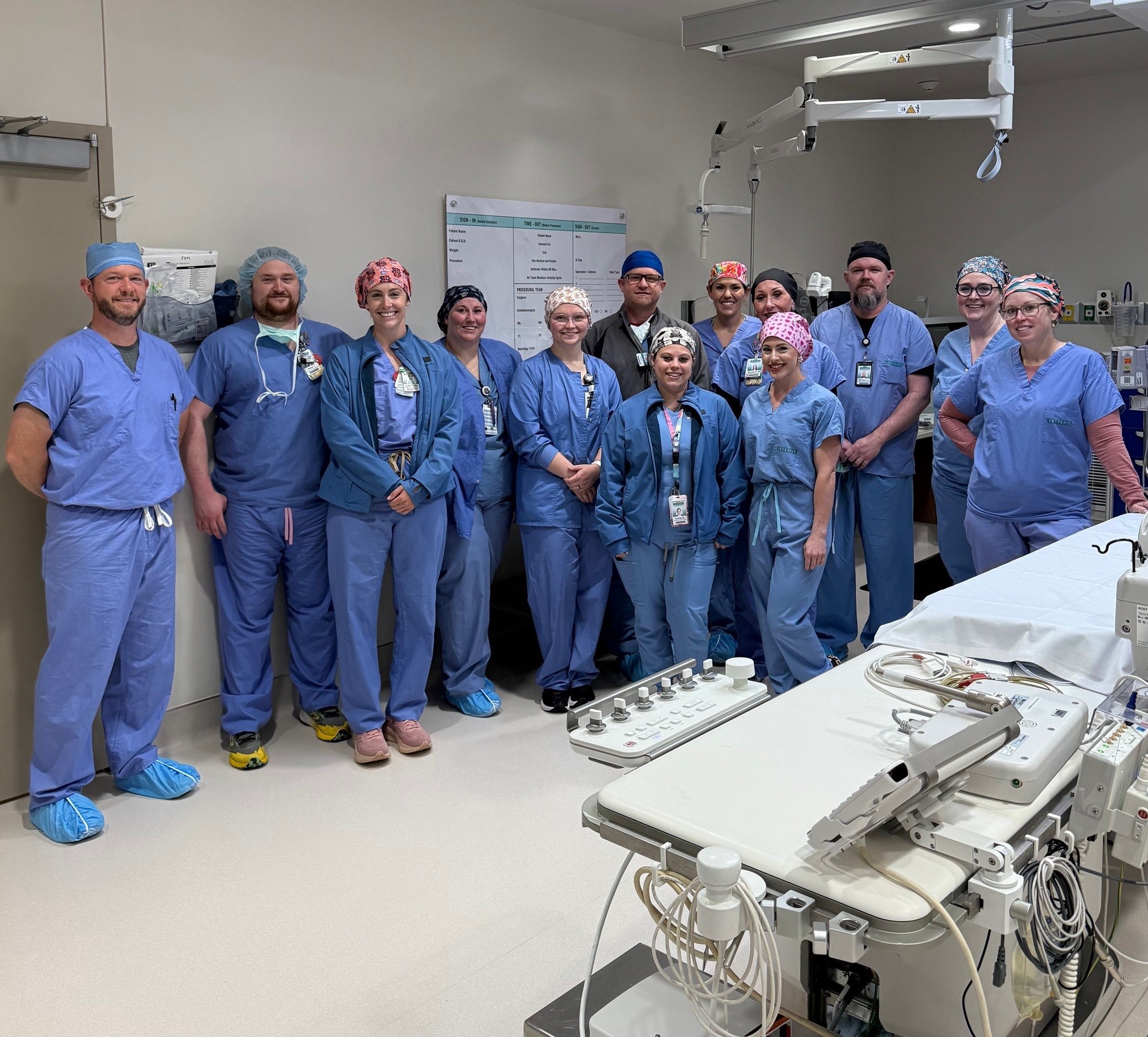 Group of health care workers in scrubs posing and smiling 