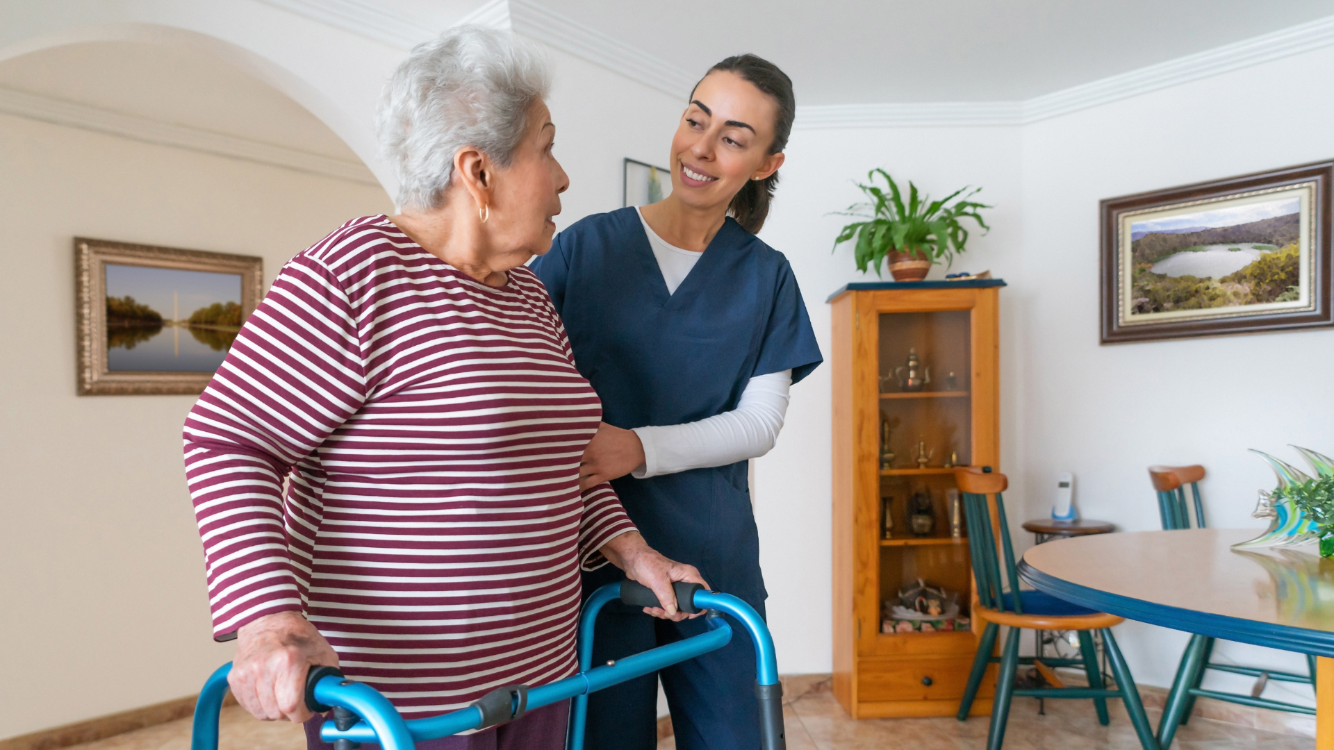 Home caregiver helping a senior woman using a walker at home