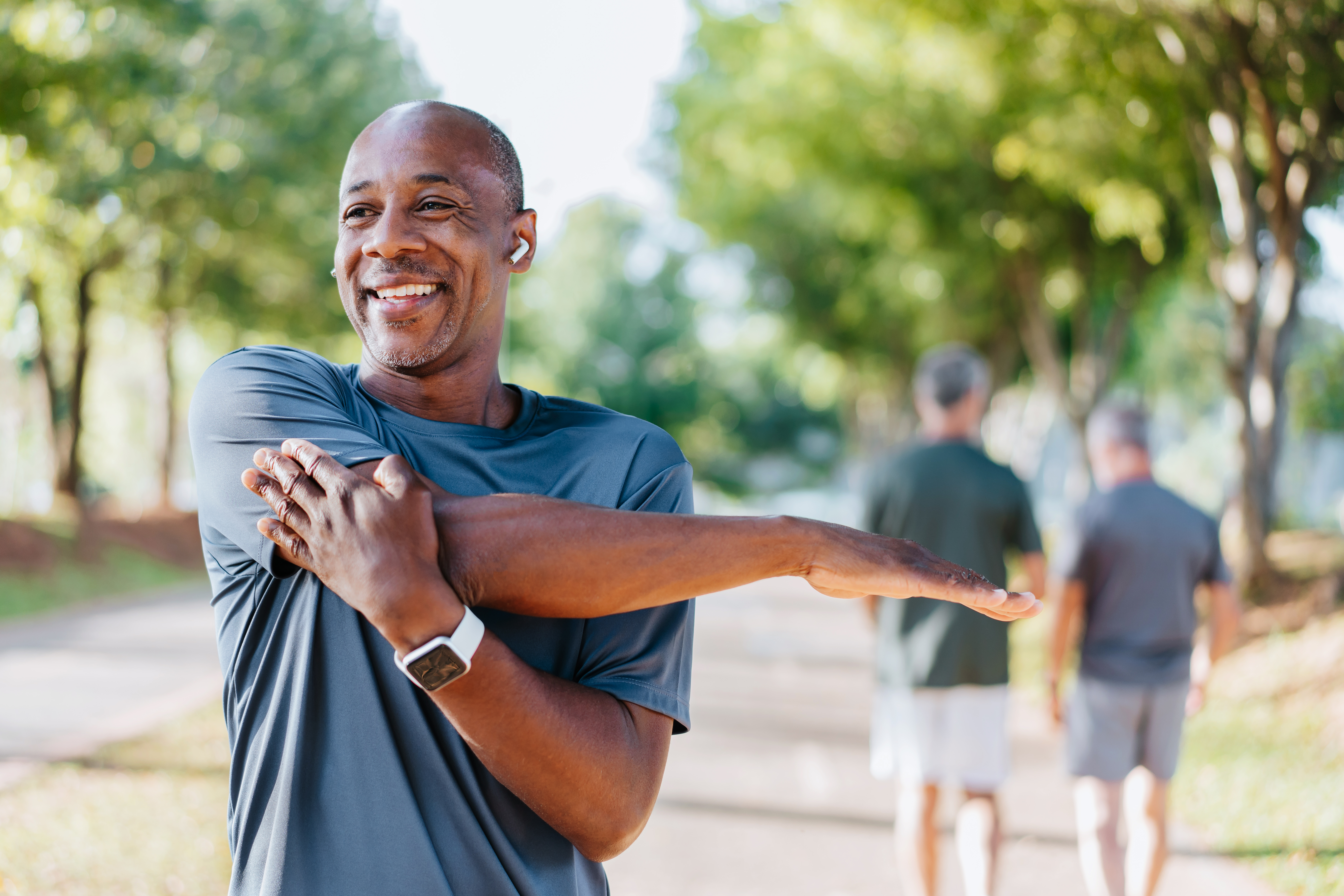 Man stretching his shoulder in the park