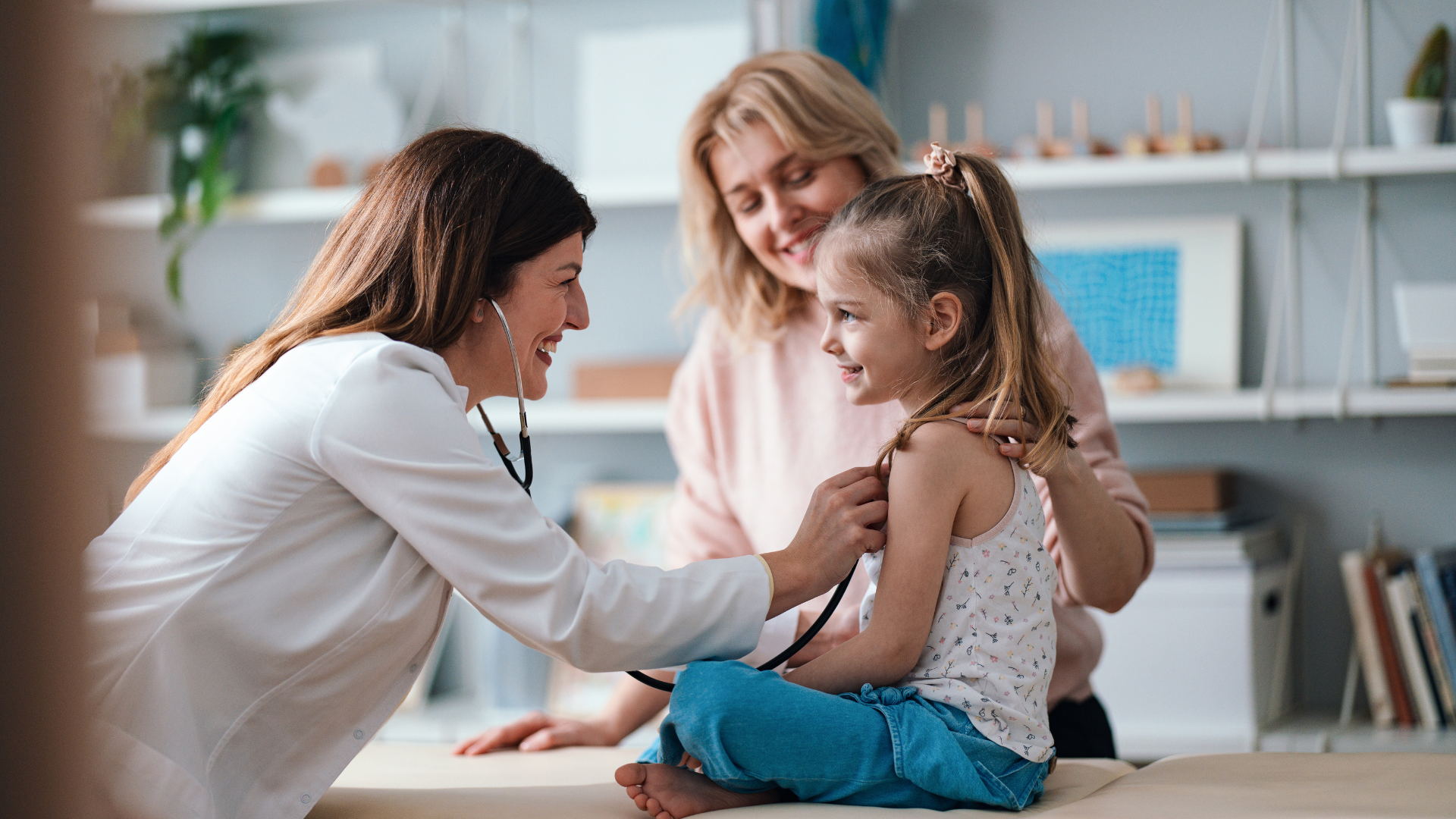 Smiling Pediatrician Examining a Cheerful Young Girl During a Checkup