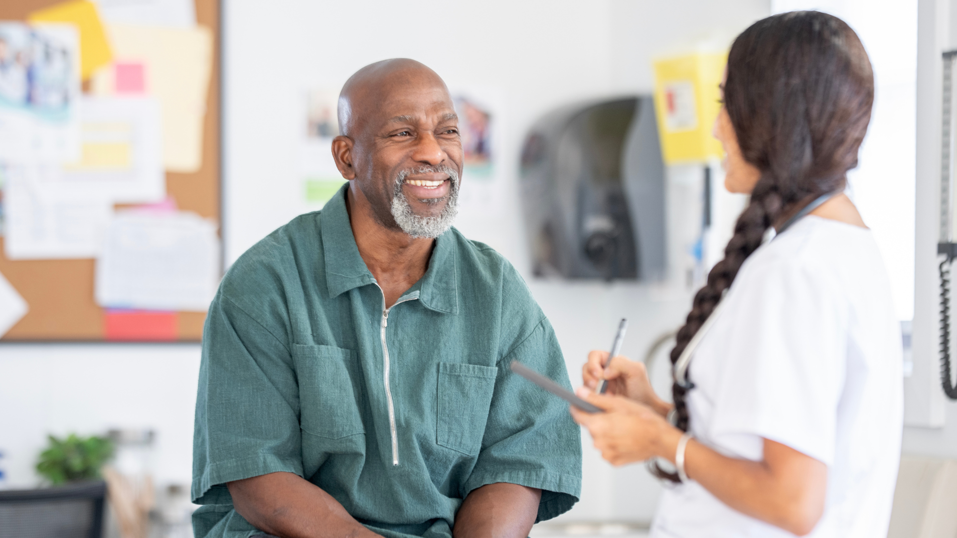 Smiling Patient Talks With Nurse During Medical Checkup in a Clinic Setting