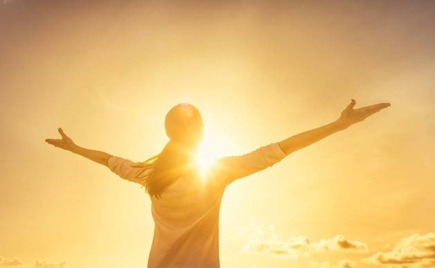 Woman with arms open towards the sky