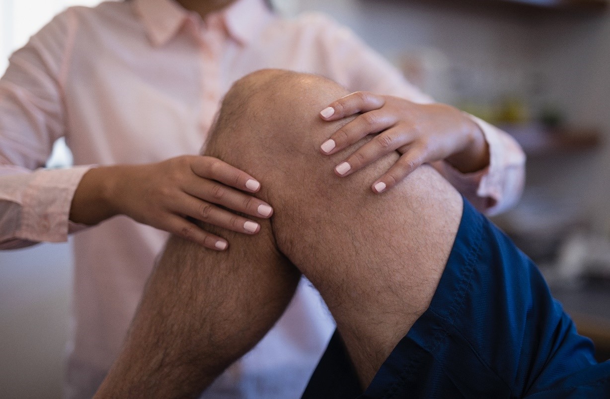 physician checking knee stiffness on patient