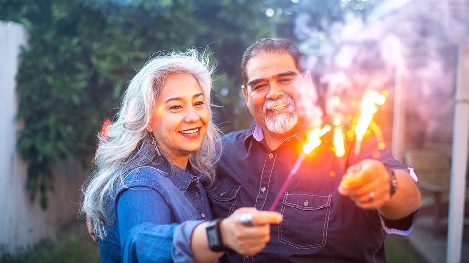 Senior couple holding sparklers together