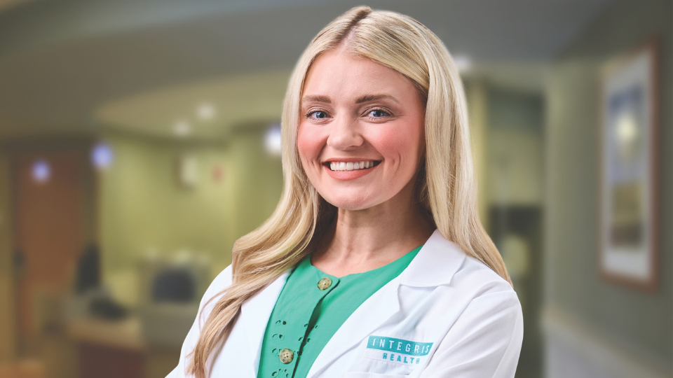 Anna Hooks smiling and posing in a white coat
