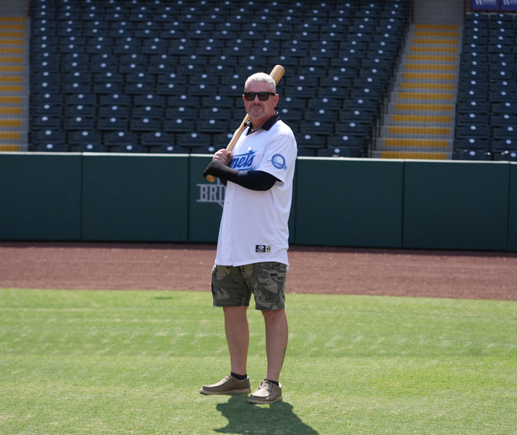 Chris Campbell in an OKC Comets uniform holding a bat while standing on the baseball field