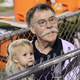 David Walker holding his grandson and smiling