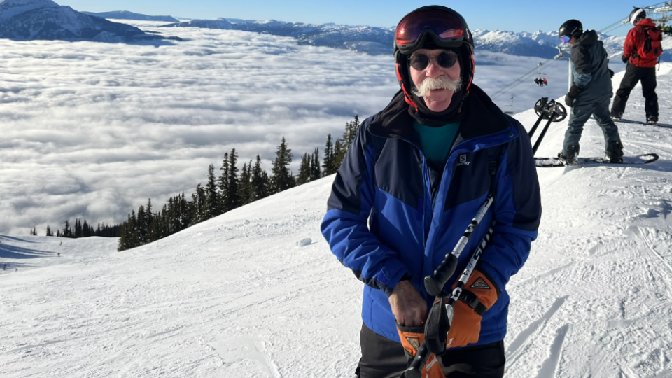 David Walker smiling on top of a snowy mountain