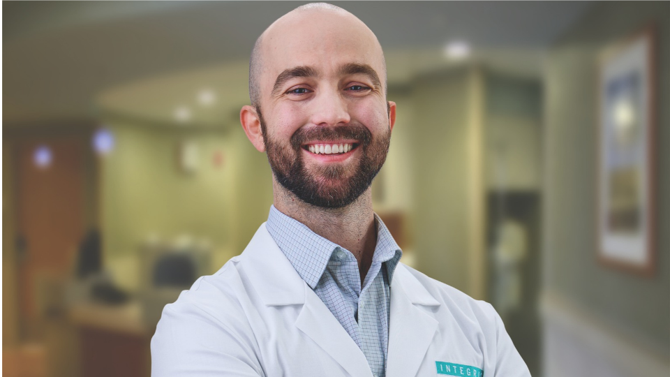 John Buie smiling and posing in a white coat