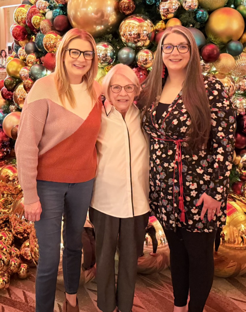 Kathy Allen smiling and posing with two women