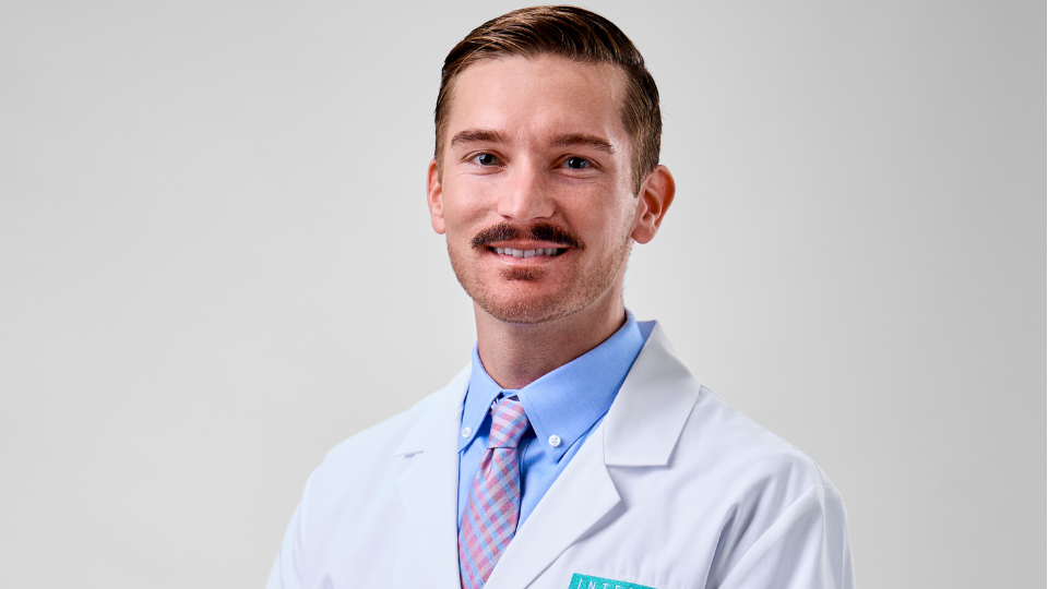 Matt Gibson posing and smiling in a white coat