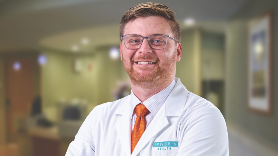 Matthew Frantz smiling and posing in a white coat
