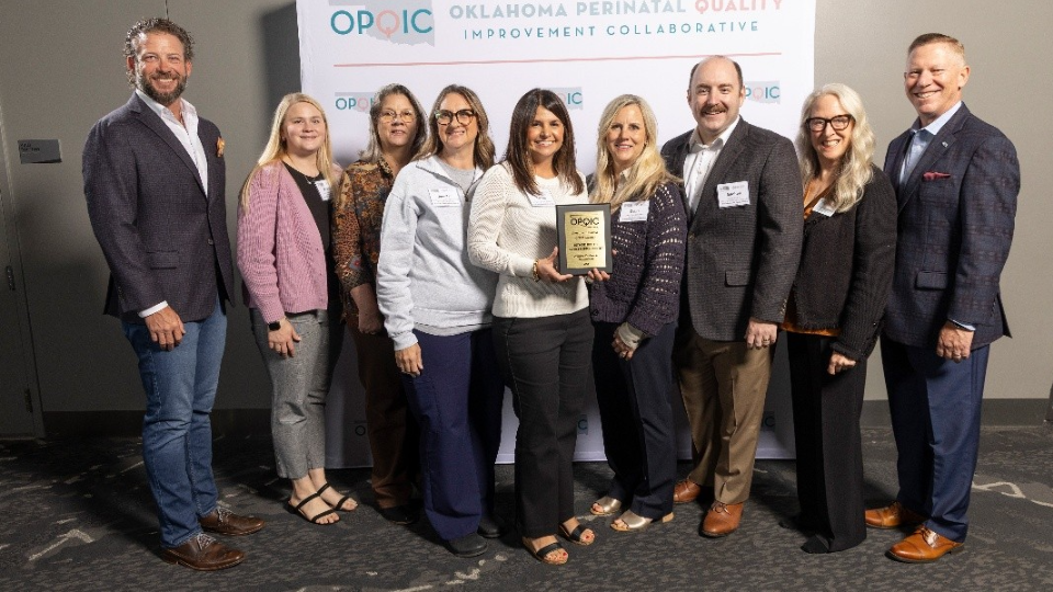 A group of individuals standing together, around an award