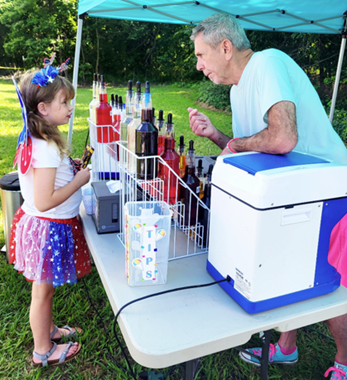 Phillip Eagleton handing out a sno cone to a child