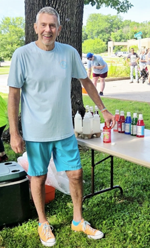 Phillip Eagleton posing and smiling next to his sno cone stand