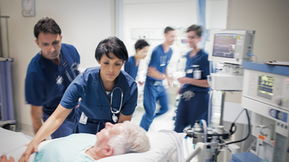 Health care workers in the emergency room helping a patient at a quick pace