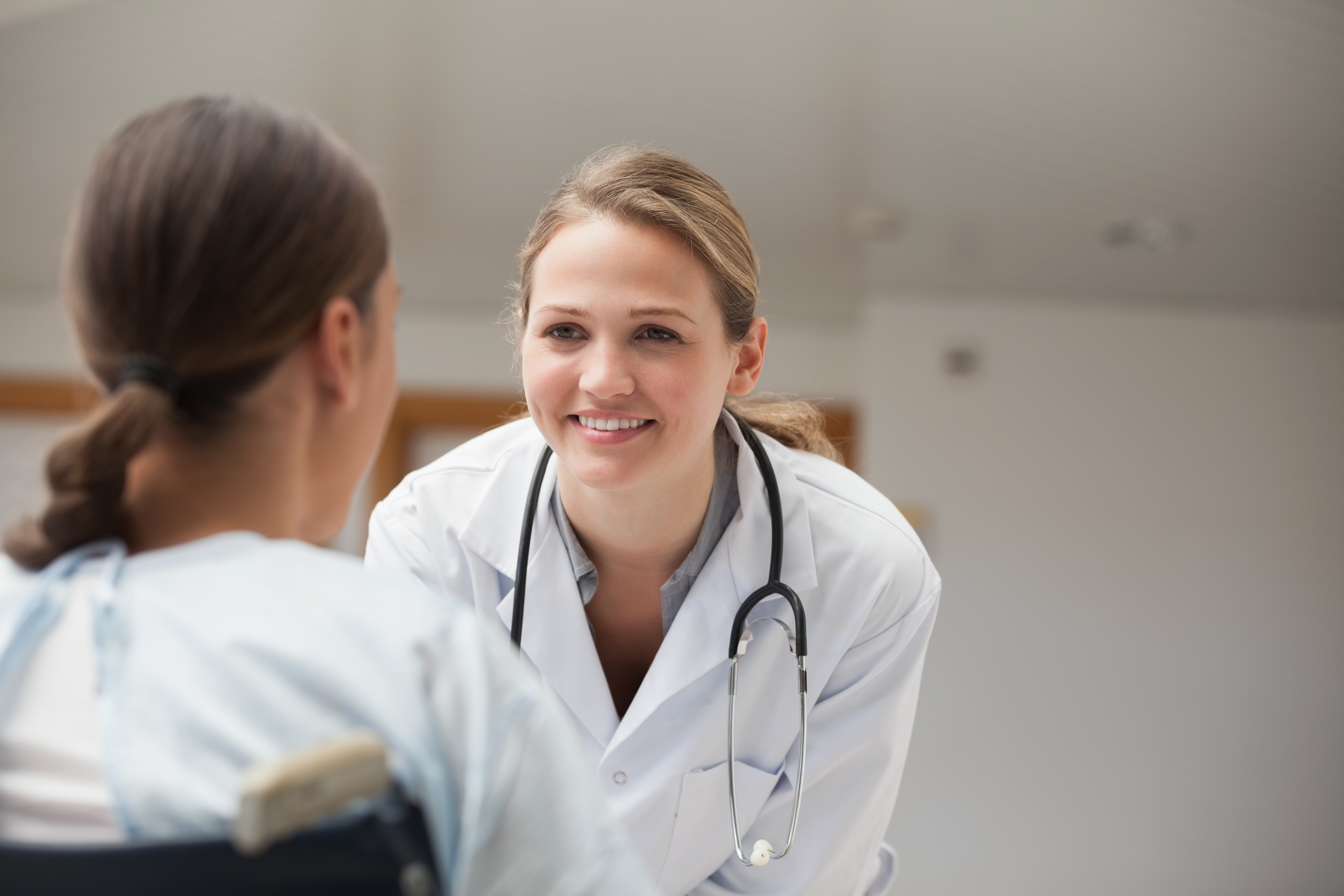 Doctor smiling at patient in a wheelchair