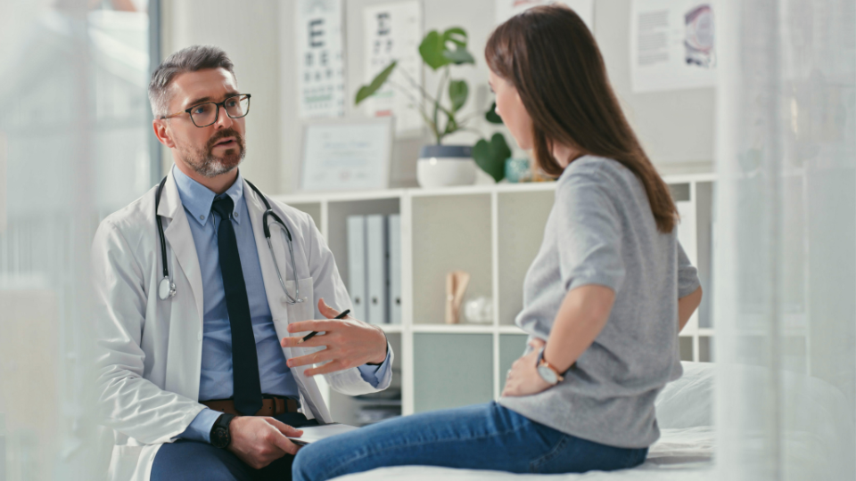 A gastroenterologist helping a patient