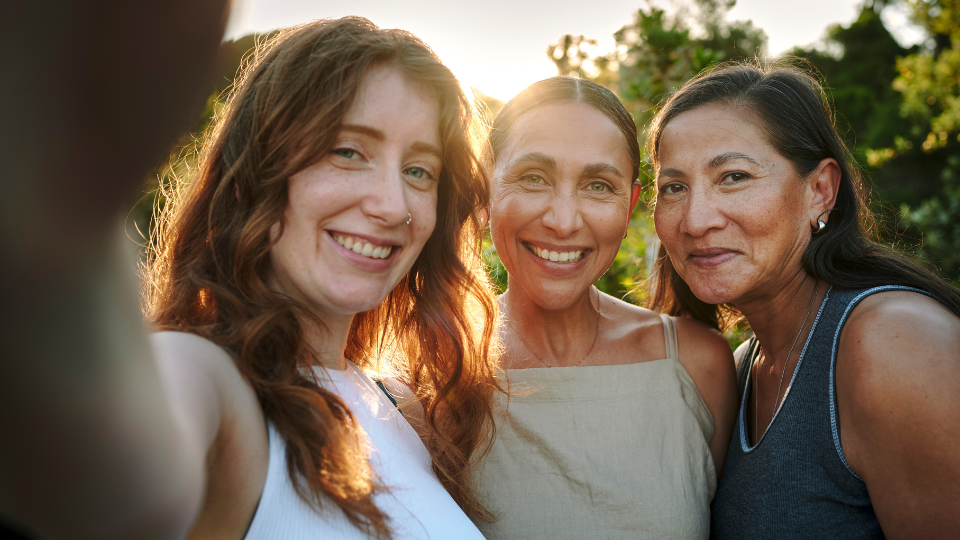 Three women smiling and hugging
