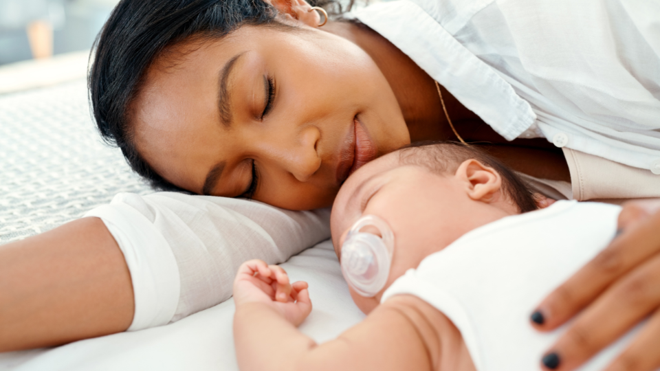 Tired mom resting with newborn baby