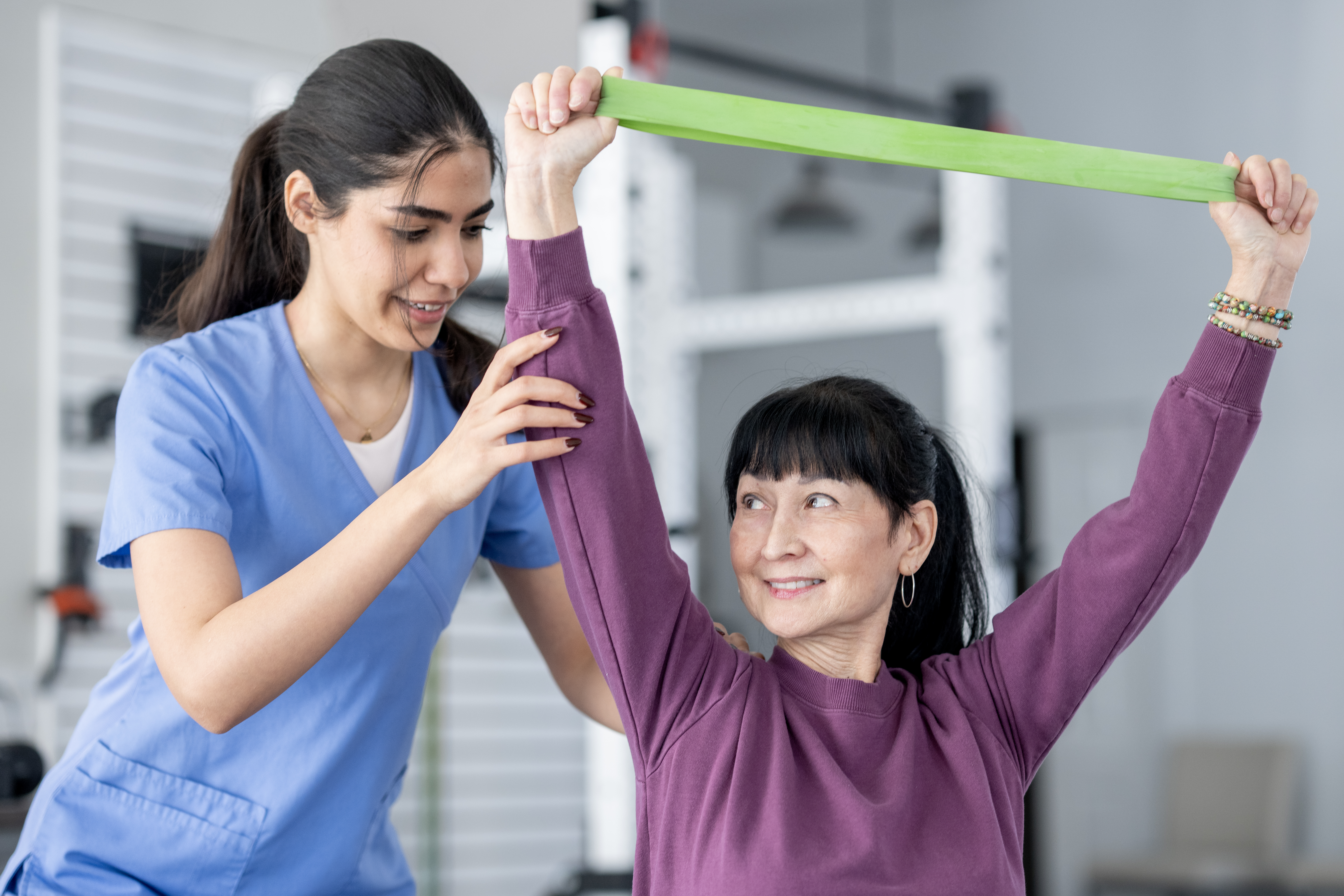 Senior woman doing band exercises at physical therapy