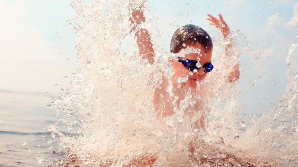 A photo of a child playing in a lake