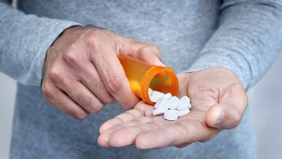 man holding pills in his hand
