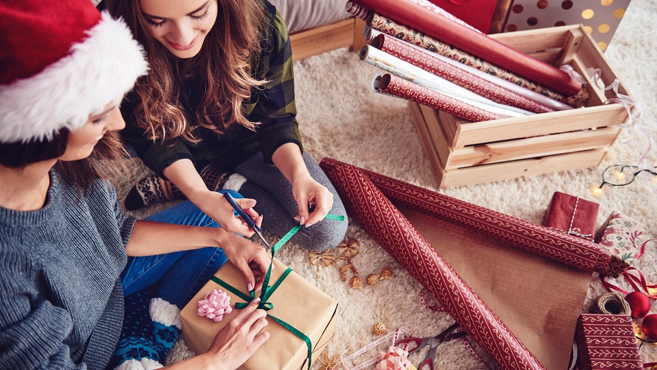 two women wrapping holiday gifts