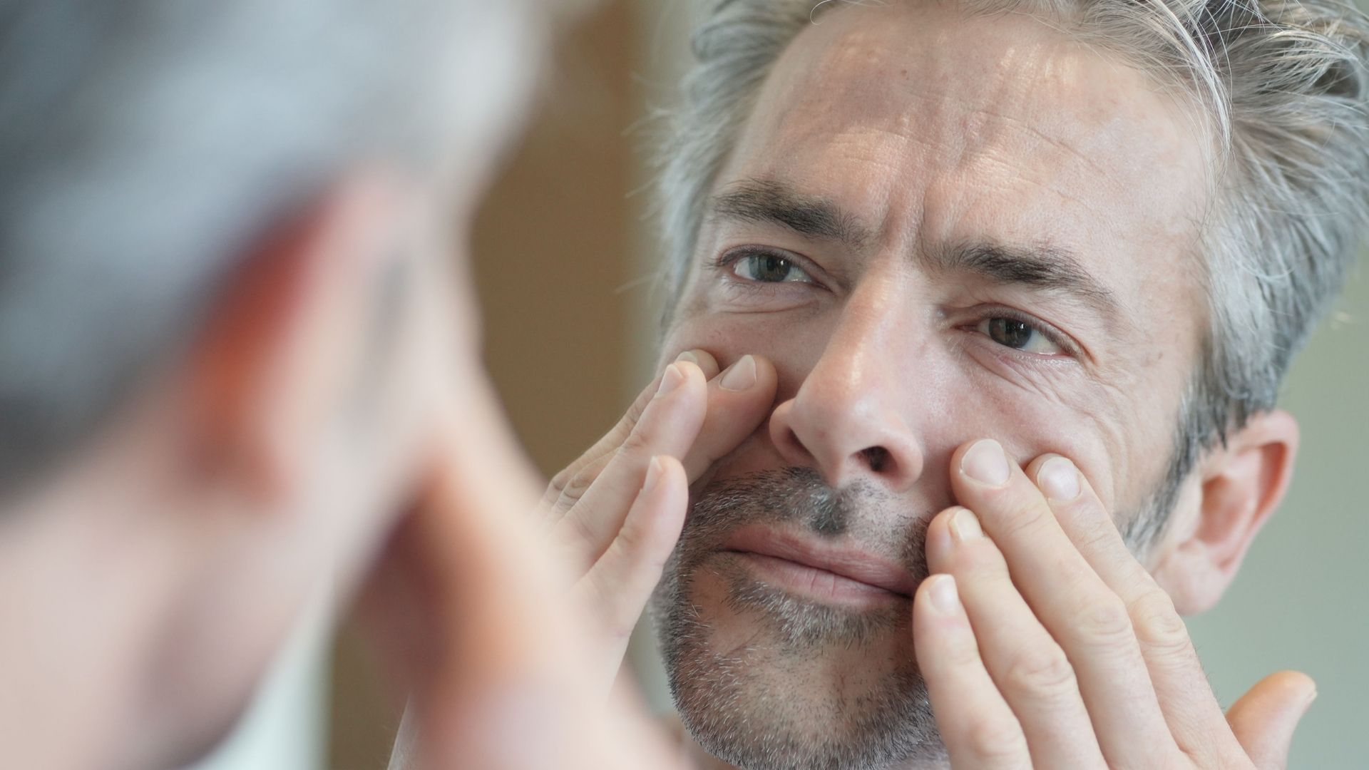 man checking for skin cancer