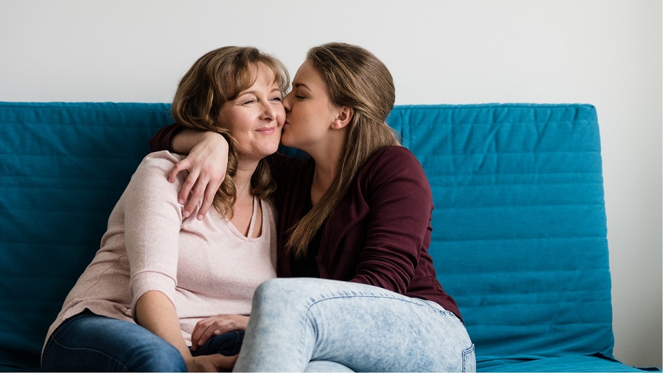 young woman kissing her mother on the cheek