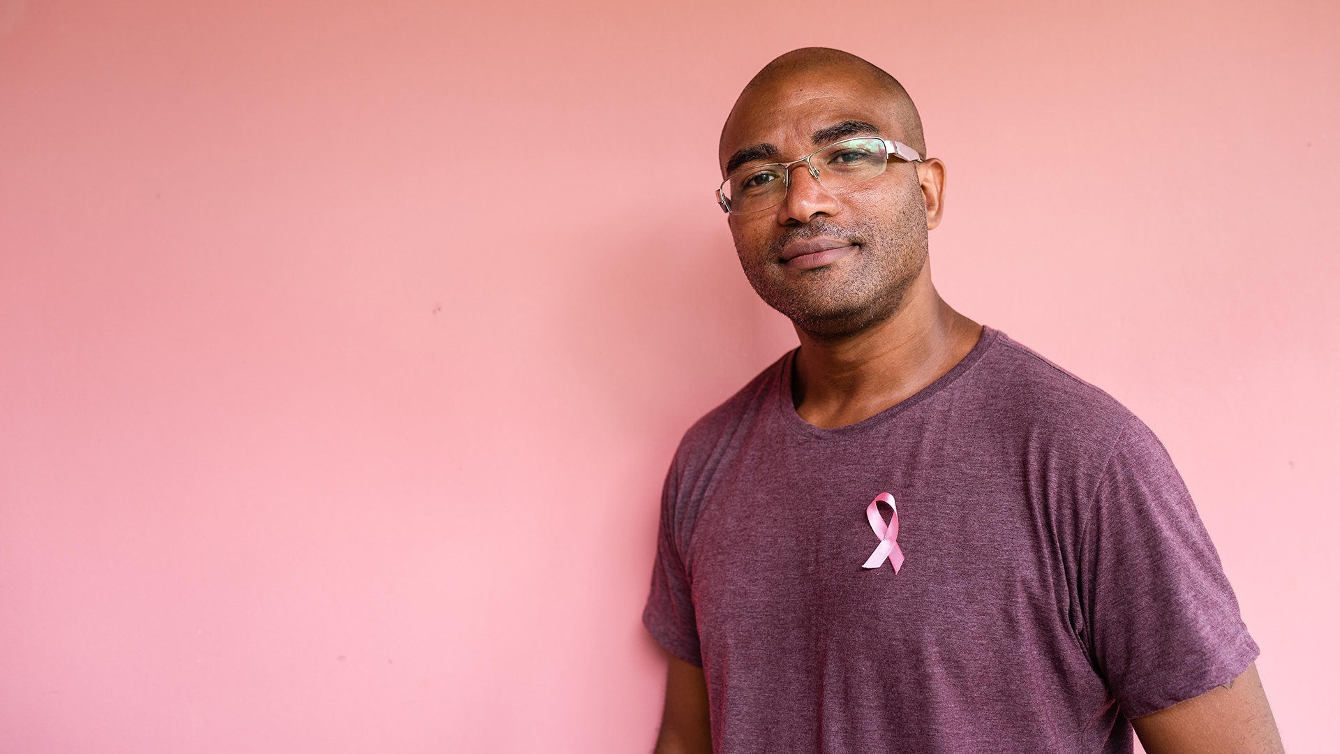 a man is shown wearing a pink breast cancer ribbon on his shirt