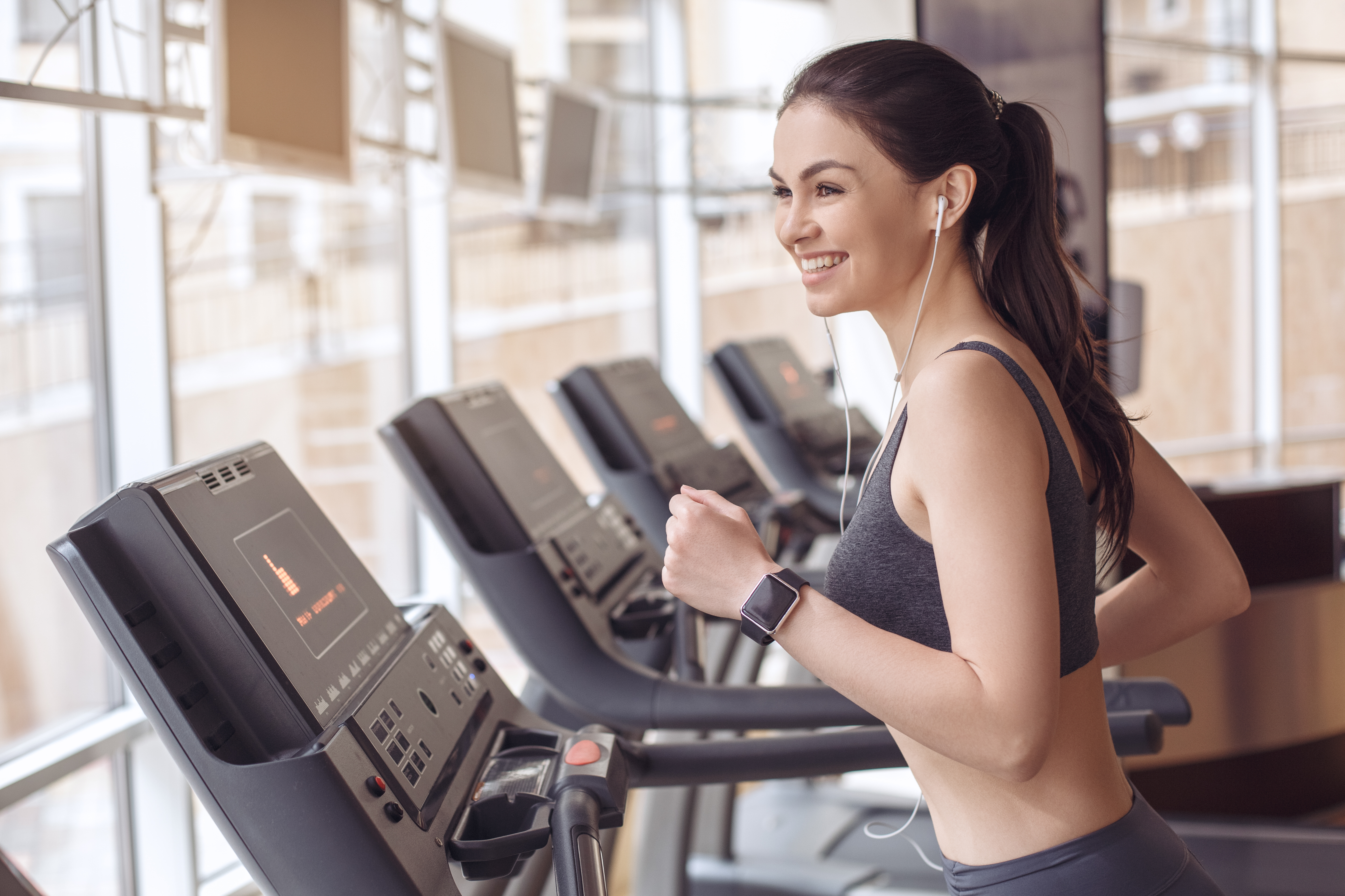 A woman runs on a treadmill at the gym
