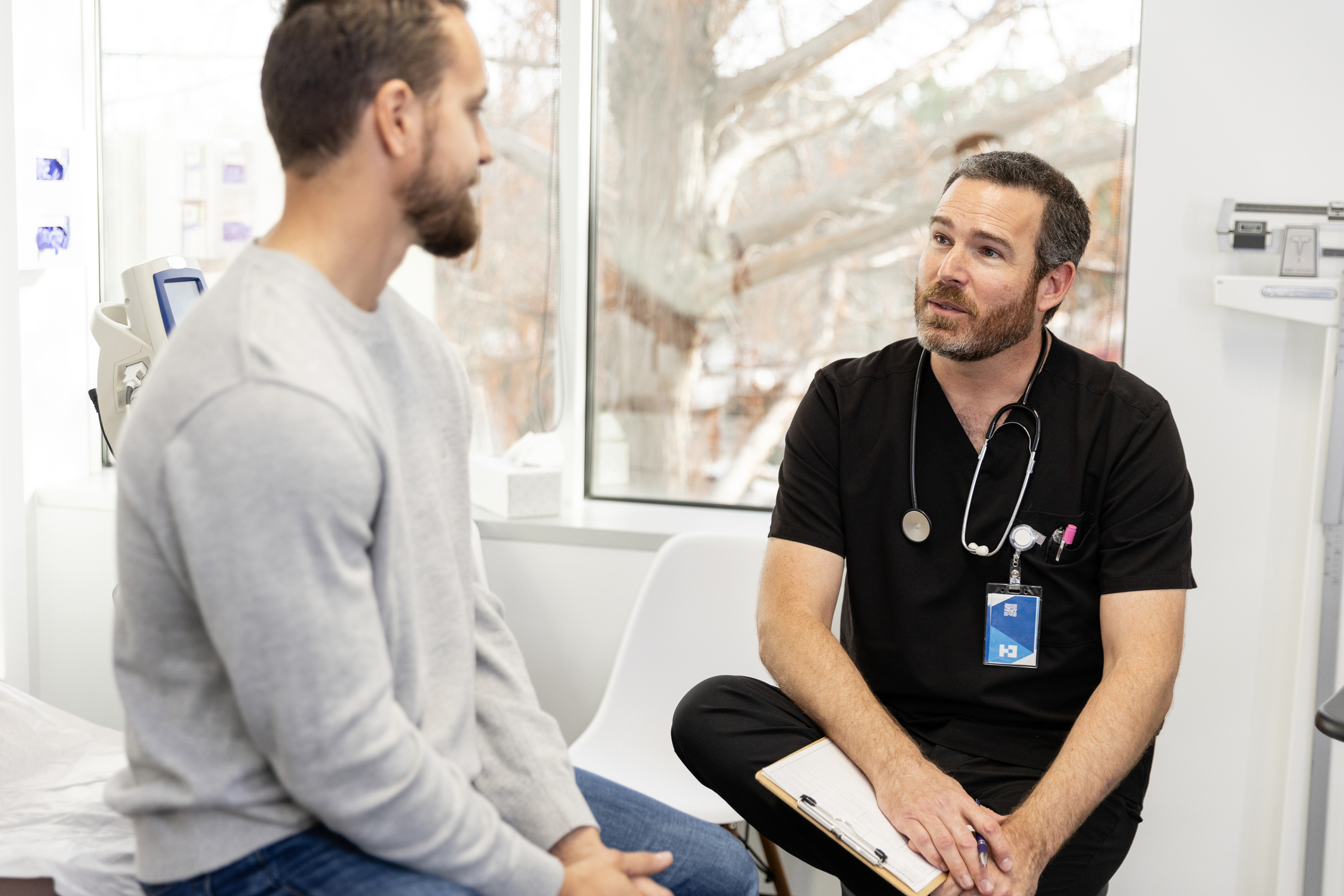 younger man speaks to a surgeon