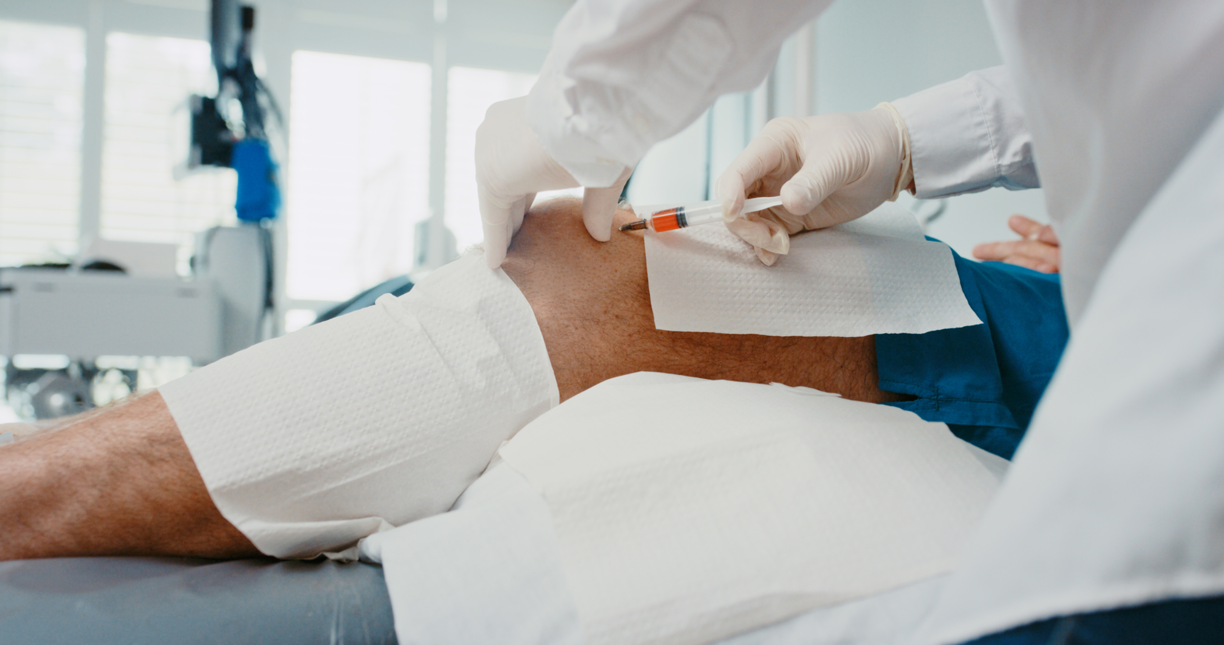 A physician putting a cortisone injection to the knee