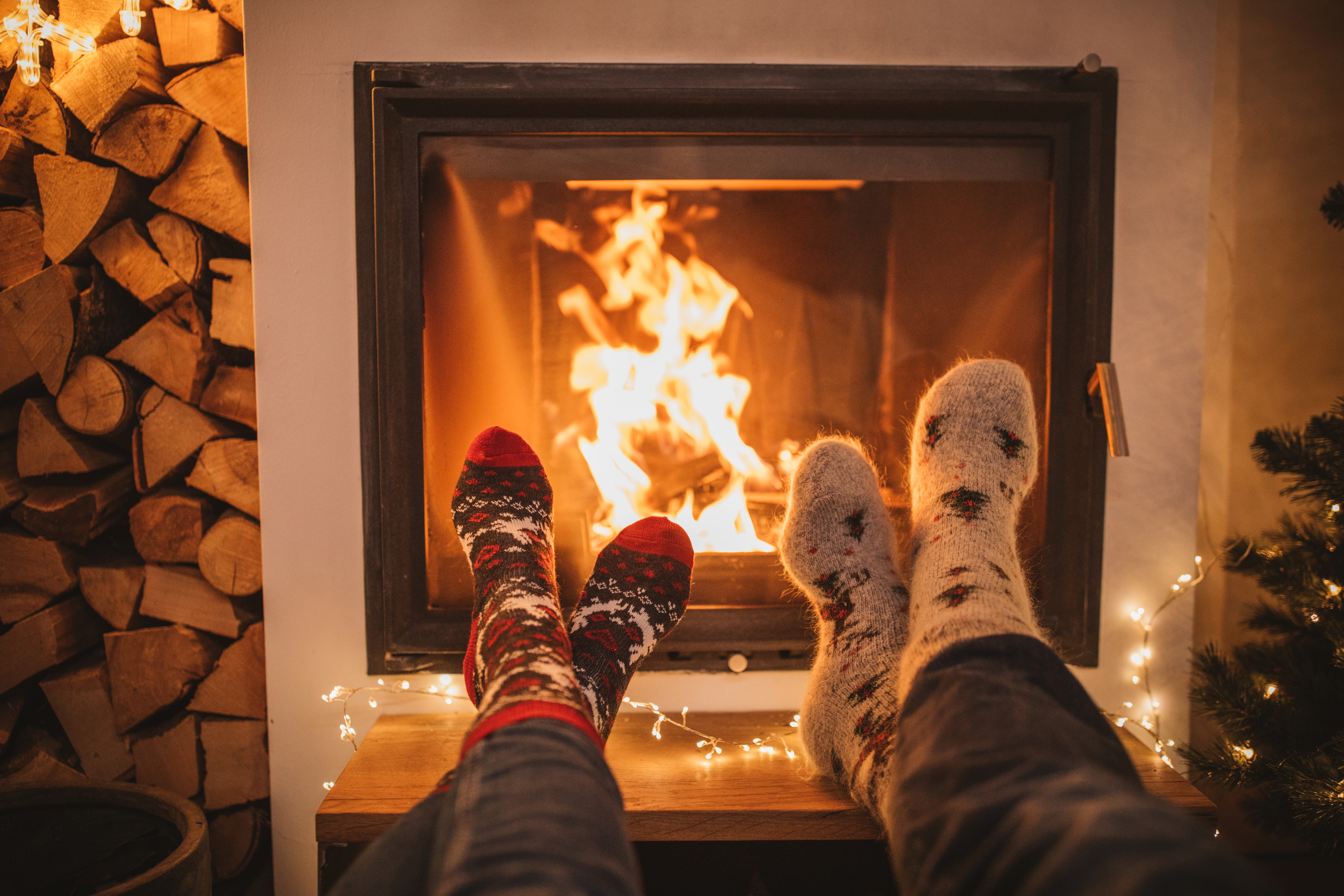photo shows two people with their feet extended, resting near the fireplace