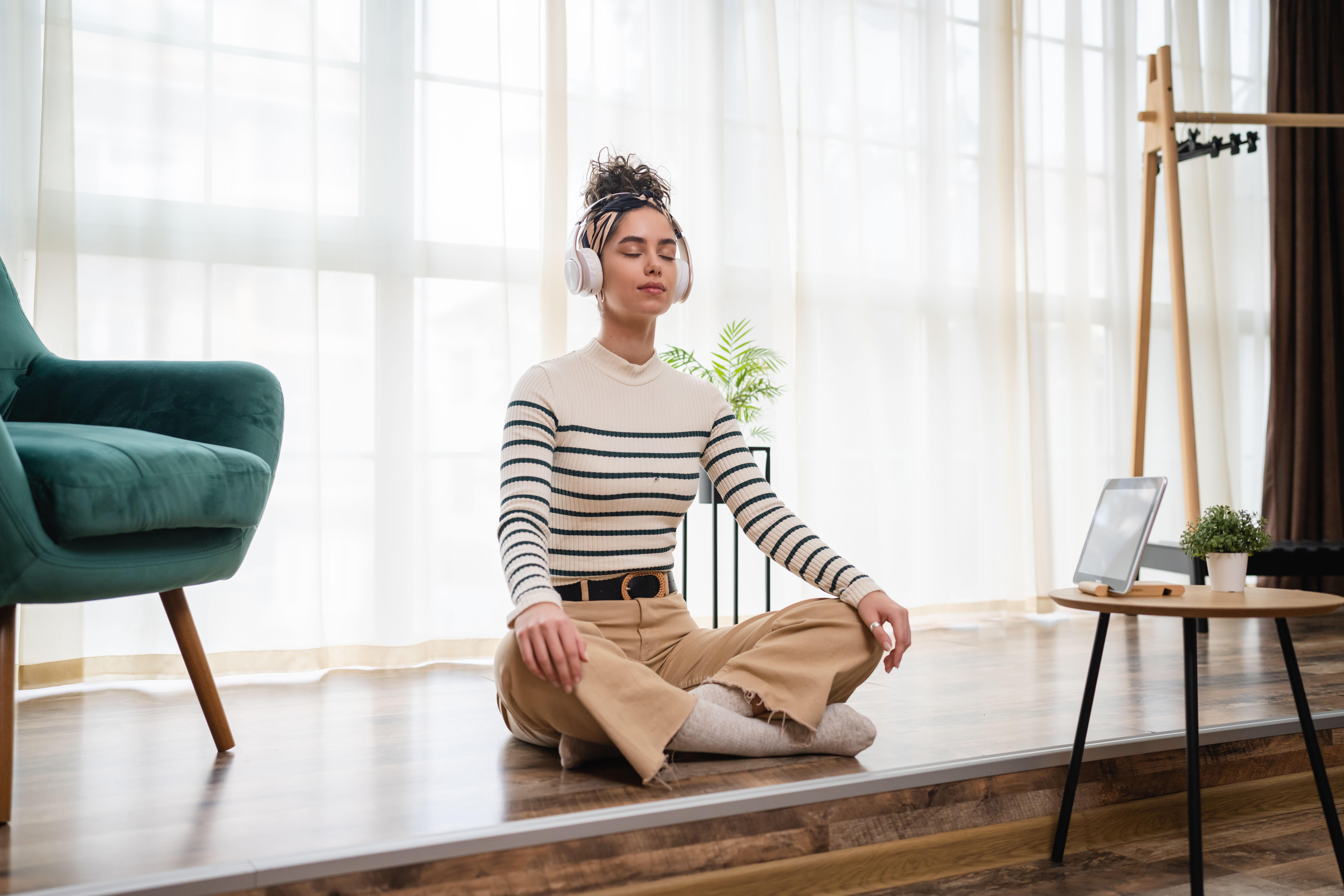 A woman sits listening to calming music