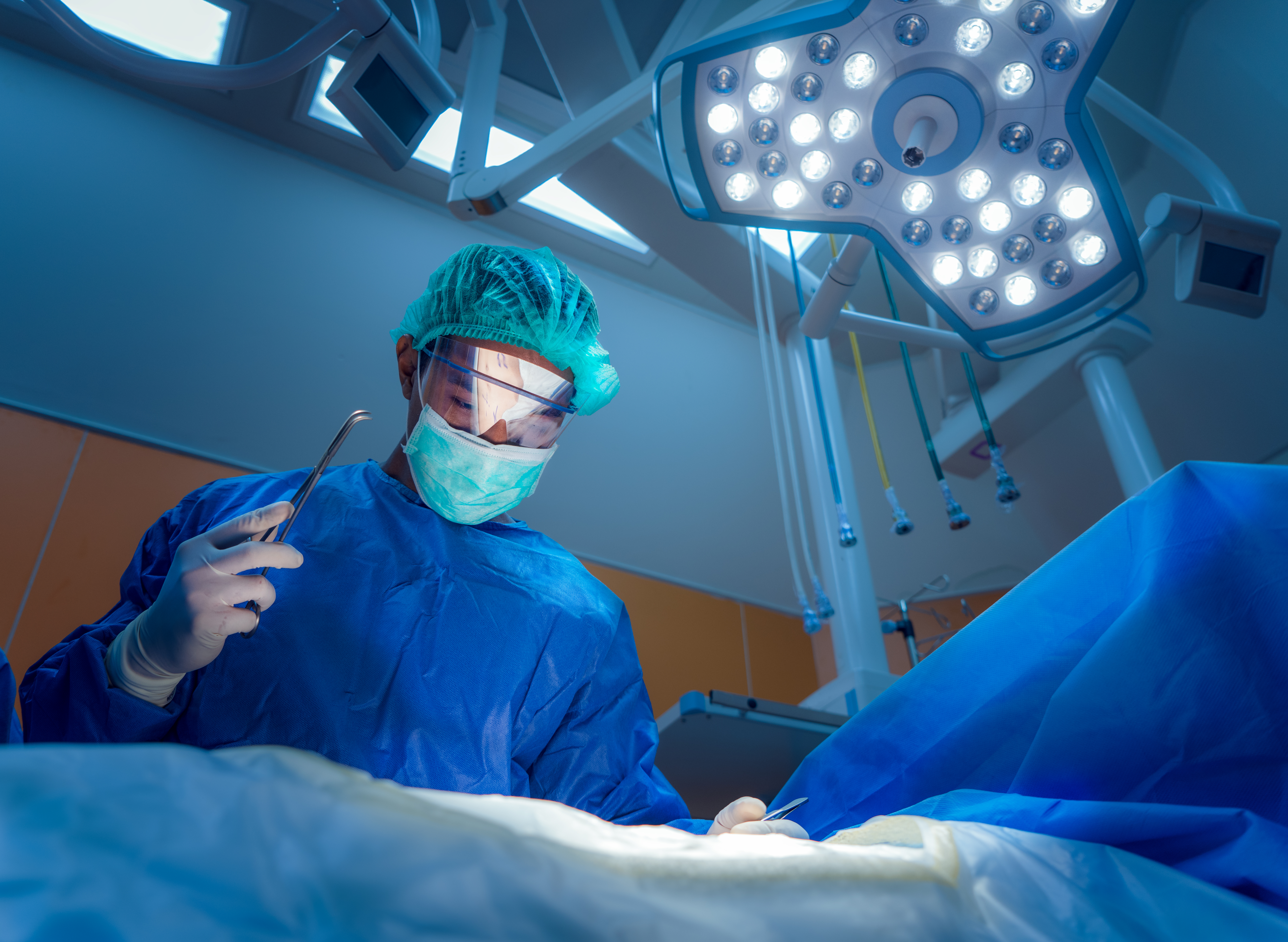 a surgeon wearing protective gear operating on a patient