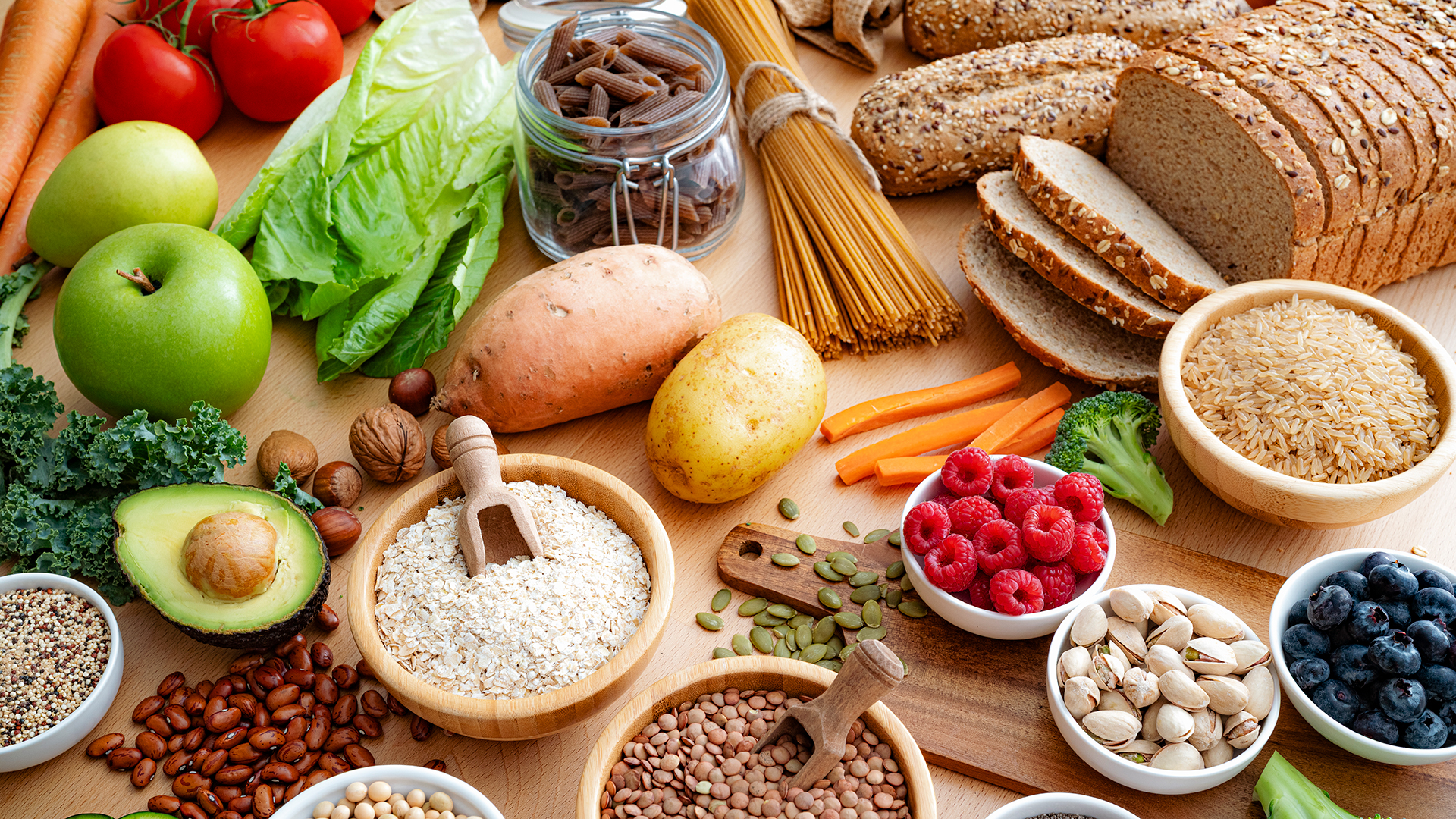 several fiber rich foods are shown on a table with fruits, whole grains, seeds, nuts and vegetables